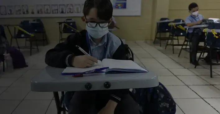 Alumno escribiendo en el aula