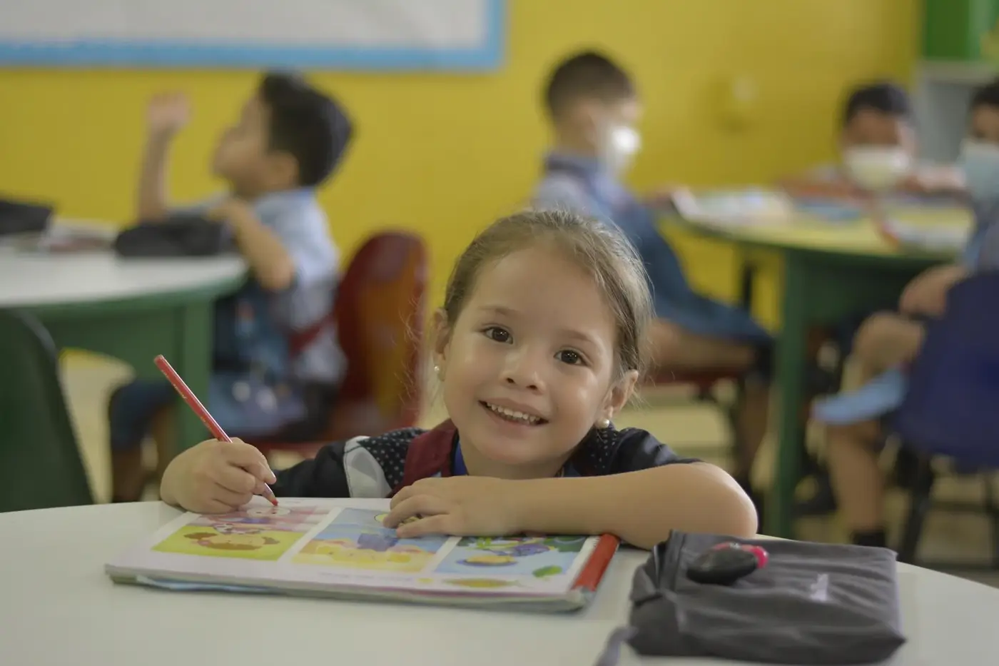 Niña de Parvularia dibujando en su cuaderno